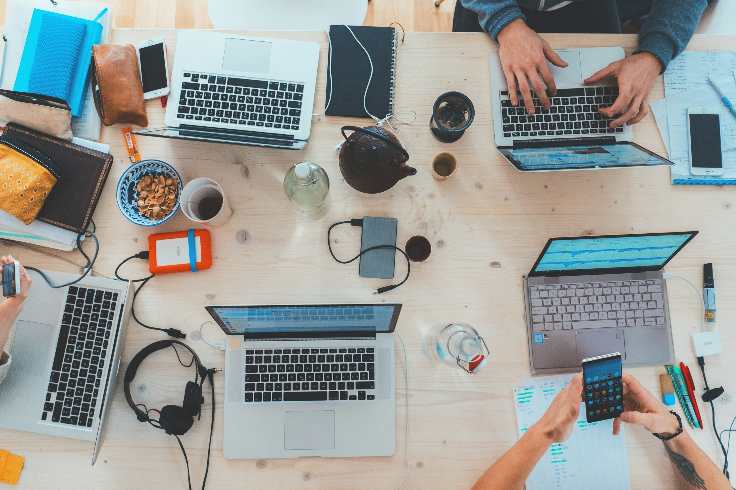 Gemeinsamer Arbeitstisch mit Laptops und Unterlagen